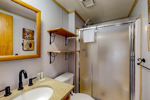 a bathroom with a shower and a toilet and a sink at Pine Woods Cabin in McHenry