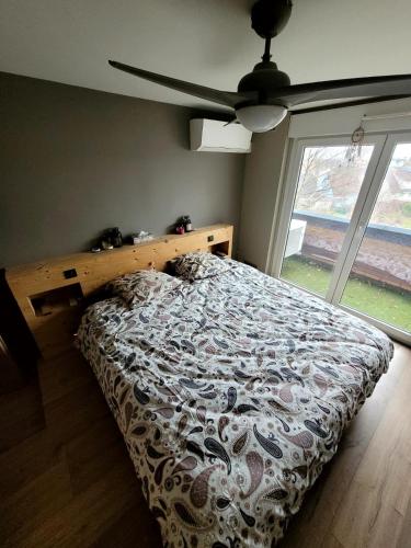 um quarto com uma cama e uma grande janela em STRASBOURG em Estrasburgo