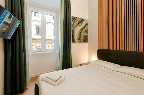 een slaapkamer met een bed en een raam bij Ottaviano Design Apartment at the Vatican in Rome