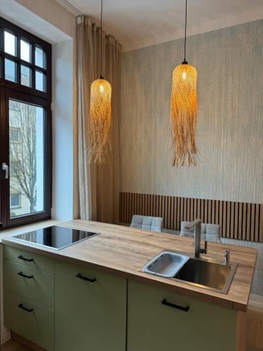 een keuken met een wastafel en twee hanglampen bij H-36 RESIDENCE 1.1 in Koblenz