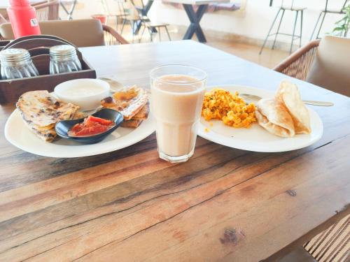 een tafel met twee borden voedsel en een glas melk bij Dashing Desert Camps & Resort in Sām