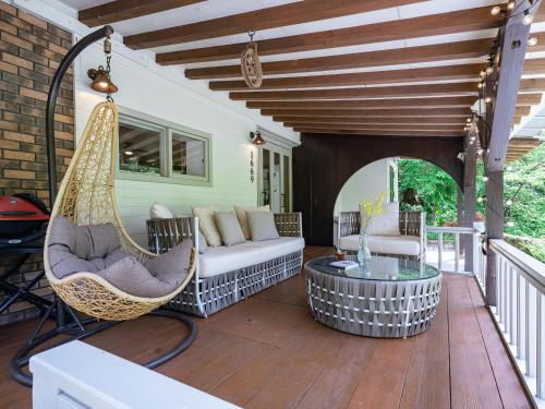 a porch with a swing and a hammock at Yama'oto - Nature Luxury Stay in Motobu