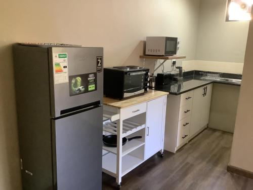 a kitchen with a refrigerator and a microwave at The Bells in the berg flat in Underberg