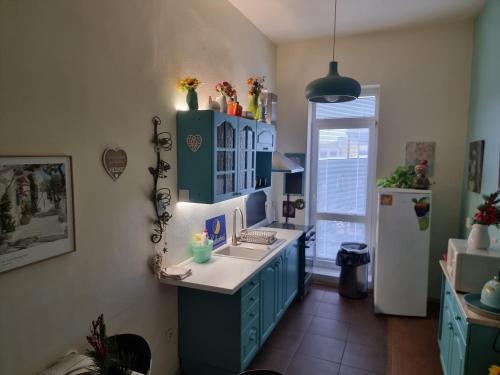 a kitchen with a sink and blue cabinets and a refrigerator at Penzion a Víno in Břeclav