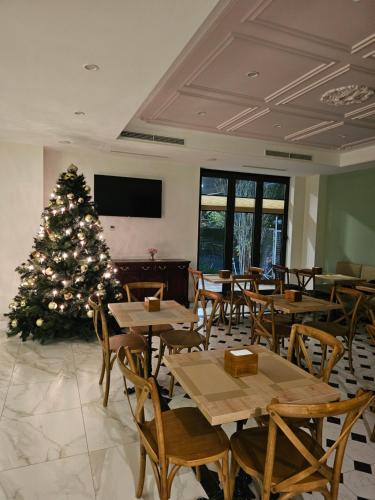 a christmas tree in a restaurant with tables and chairs at Hotel Avenue 30 in Yerevan