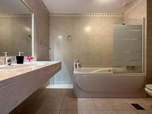 豐沙爾的住宿－Plaza near Forum Madeira，带浴缸、盥洗盆和卫生间的浴室