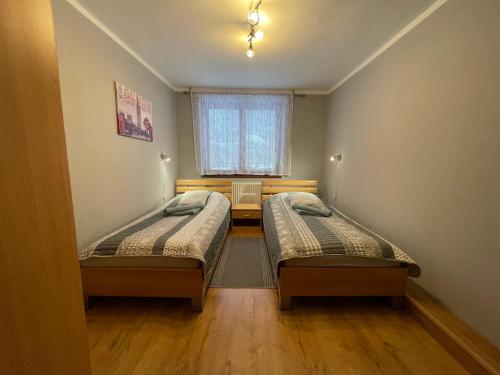 two beds in a small room with a window at Apartmán Stráne in Martin