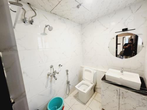 a white bathroom with a sink and a toilet at THE GREENSTAR INN PREMIUM in Bhubaneshwar