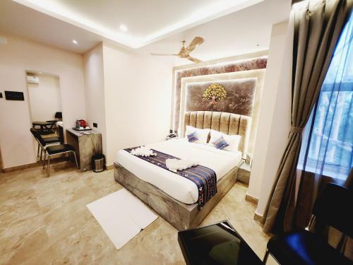 a bedroom with a bed and a desk and a window at THE GREENSTAR INN PREMIUM in Bhubaneshwar