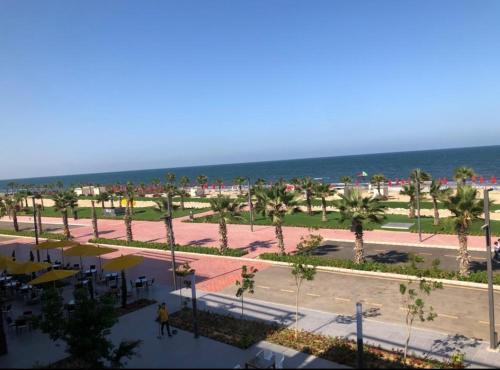 - une vue sur la plage bordée de palmiers et l'océan dans l'établissement Porto said resort, à `Ezbet Shalabi el-Rûdi