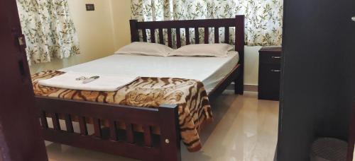 een slaapkamer met een bed met een houten bedframe bij Manjippuzha Nature Space in Alleppey