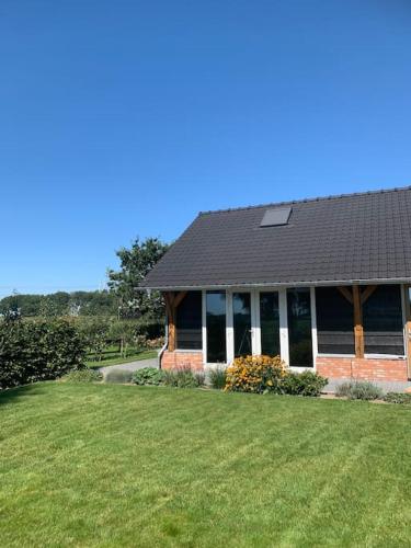 a house with a large lawn in front of it at Vakantiehuis Hollestelle in Ovezande