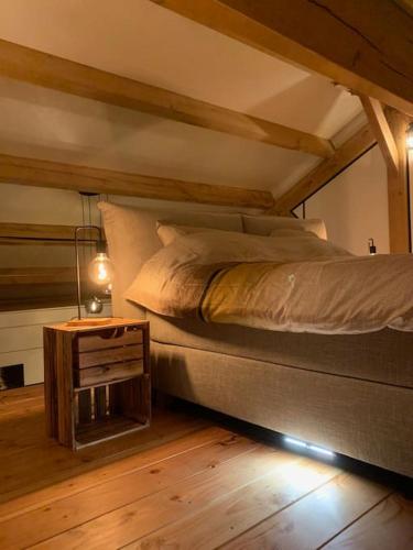 a bedroom with a bed and a night stand at Vakantiehuis Hollestelle in Ovezande