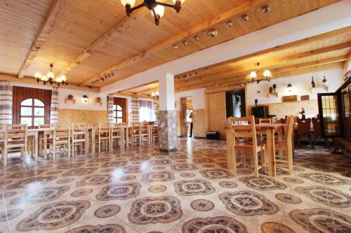 a large room with wooden tables and chairs at Felső Fogadó in Felsőtold