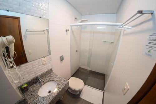 a bathroom with a shower and a toilet and a sink at Pousada Villa Atlântica in Balneário Camboriú