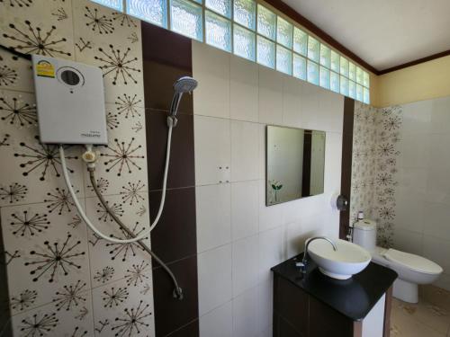 ein Bad mit einer Dusche, einem Waschbecken und einem WC in der Unterkunft Baan Khao Noi Resort in Surat Thani