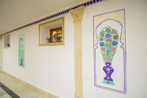 een muur met schilderijen aan de zijkant van een gebouw bij Hotel Zaringiz in Bukhara