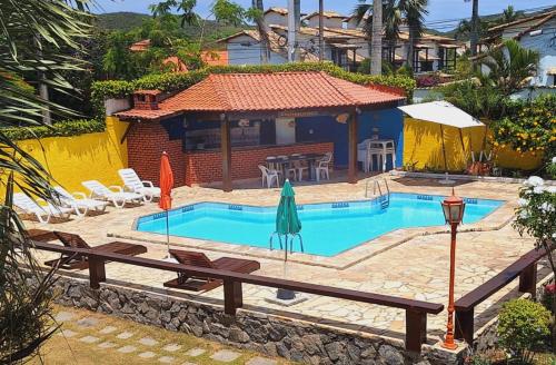 a swimming pool in front of a house at Pousada Estalage in Cabo Frio