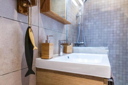 La salle de bains est pourvue d'un lavabo blanc et d'un comptoir. dans l'établissement La Piboule - Au Coeur du Panier T2 -39m2, à Marseille