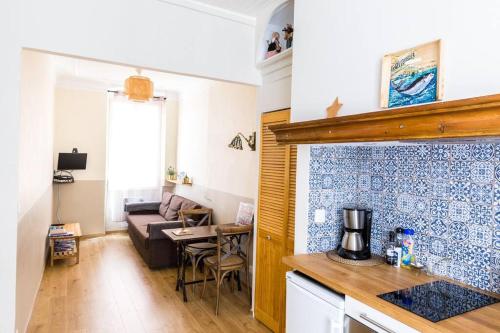 une cuisine et un salon avec un canapé et une table dans l'établissement La Piboule - Au Coeur du Panier T2 -39m2, à Marseille