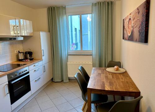 Modernes Zwei-Zimmer-Apartment Chemnitz - Kaßberg في شيمنيتز: مطبخ مع طاولة خشبية وطاولة وكراسي