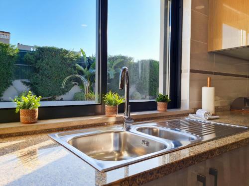 un lavandino in acciaio inossidabile in una cucina con finestra di Casa Limão - Private Pool - Beach & Center (650m) a Carvoeiro