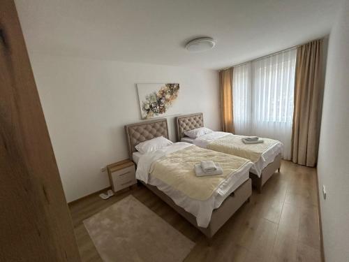 a bedroom with two beds and a window at CENTRAL Aparments in Novi Pazar