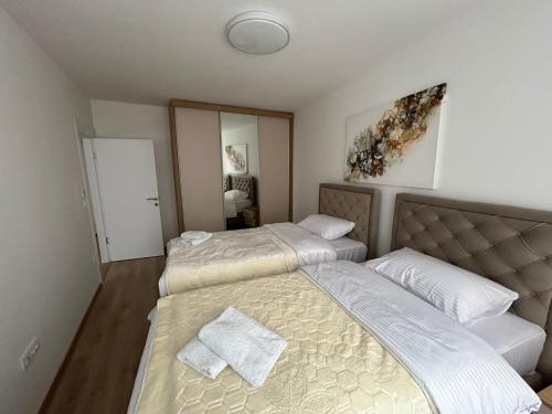 a bedroom with two beds and a mirror at CENTRAL Aparments in Novi Pazar