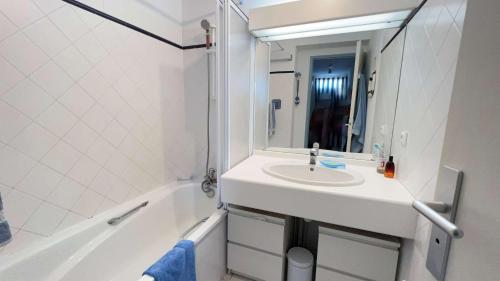 un bagno bianco con lavandino e vasca di Petite location dans résidence avec piscine et terrains de tennis a La Couarde-sur-Mer
