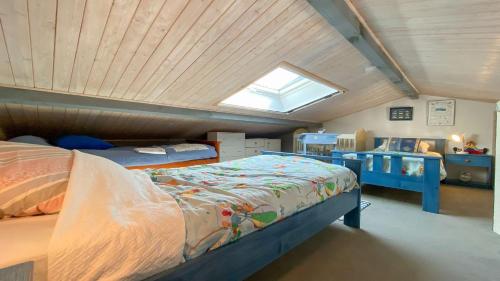 a attic bedroom with two beds and a window at Petite location dans résidence avec piscine et terrains de tennis in La Couarde-sur-Mer