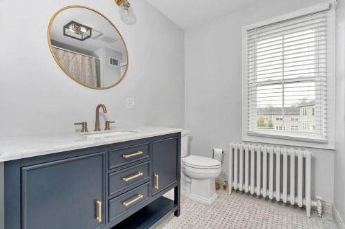 uma casa de banho com um lavatório, um espelho e um WC. em Underground Railroad 3 Bedroom Farmhouse em Kennett Square