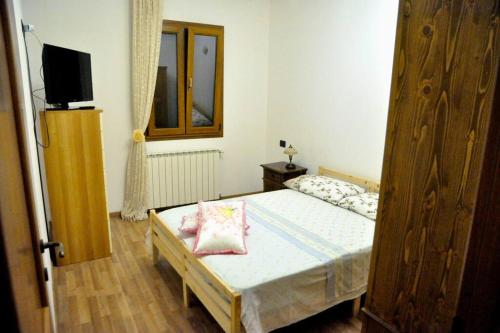 een slaapkamer met een bed en een televisie. bij Vista da Sogno, Casa di Montagna per il Tuo Relax in Villadossola