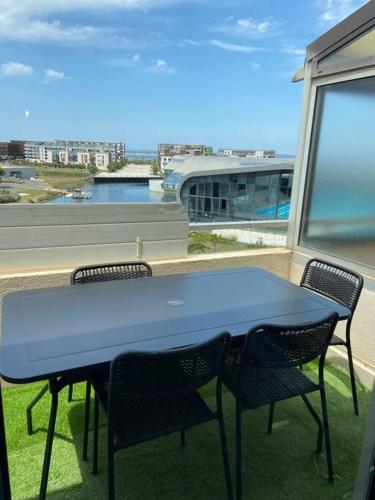 une table bleue sur un balcon avec deux chaises dans l'établissement Charmant petit studio mezzanine avec climatisation, à Sète