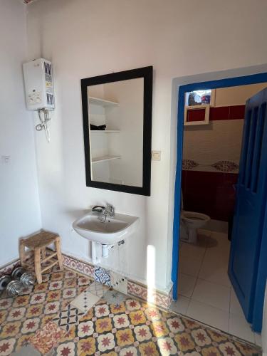 a bathroom with a sink and a mirror at Dar Isma : Une maison sur océan in Wassane