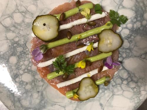 a sandwich with pickles and vegetables on a plate at Agriturismo Voeuja Lago Maggiore in Luino