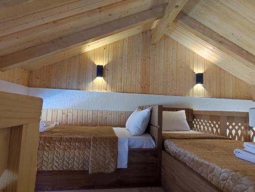 2 camas en una habitación con paredes de madera en Belvedere, en Ambrolauri