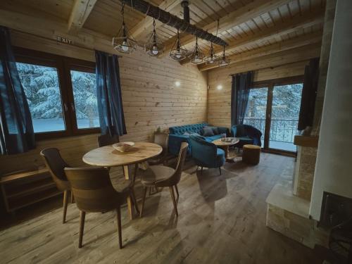 a living room with a table and chairs and a couch at Planinska kuća Dunja in Jahorina