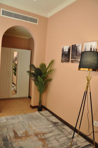 une chambre avec une lampe et une plante sur un mur dans l'établissement Luxurious Hilltop Apartment 9 minutes from Haram, à La Mecque