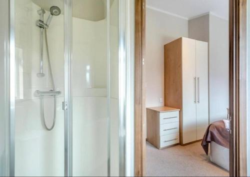 baño con ducha y armario blanco en Scottish retreat en Banchory