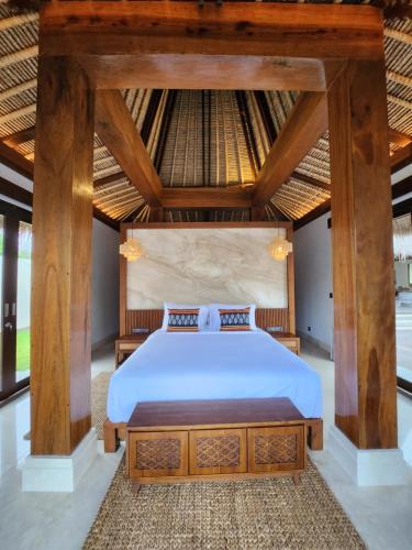 KANDORA Luxury villas في Maujawa: غرفة نوم بسرير مع مظلة خشبية