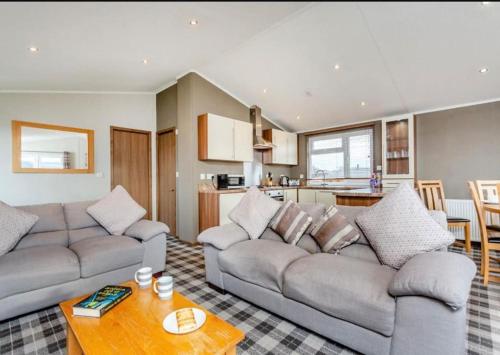 a living room with two couches and a table at Scottish retreat in Banchory
