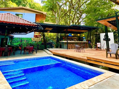een zwembad en een patio met een tafel en stoelen bij Jungle Beach Hotel Manuel Antonio in Manuel Antonio