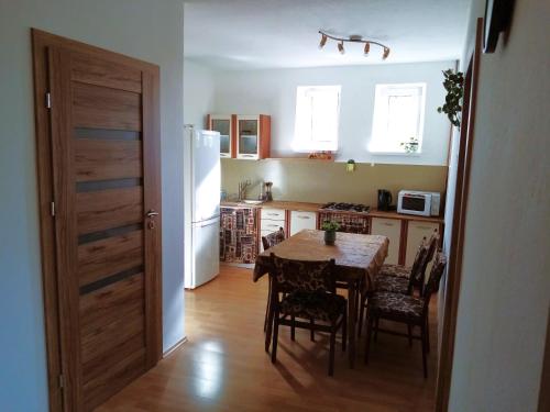 cocina con mesa, sillas y nevera en Apartment Beatris en Svit