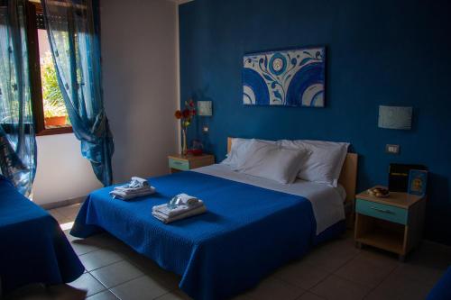 um quarto azul com uma cama com toalhas em P&P Assisi Camere em Bastia Umbra
