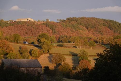 an autumn view of a farm with a house on a hill at Le Montaurier in Combrailles