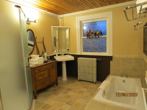 a bathroom with a bath tub and a sink and a bath tub at The Roses Heritage Inn in St. John's