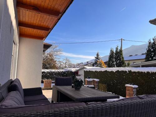 a patio with a table and couches on a house at Ferienwohnung ImZaro: Erdgeschoss, 2 Schlafzimmer plus Schlafsofa, eigener Eingang, große Terrasse mit Garten! in Spittal an der Drau