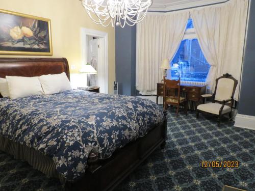 a bedroom with a bed and a desk and a chair at The Roses Heritage Inn in St. John's