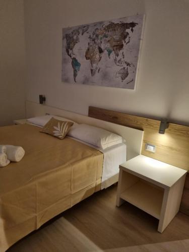 a bedroom with a bed and a map on the wall at Simona Rooms in Portocannone
