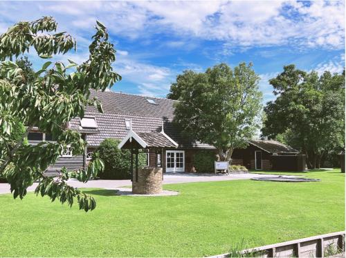a house with a green lawn in front of it at Gastenverblijf Rodenburg in Streefkerk